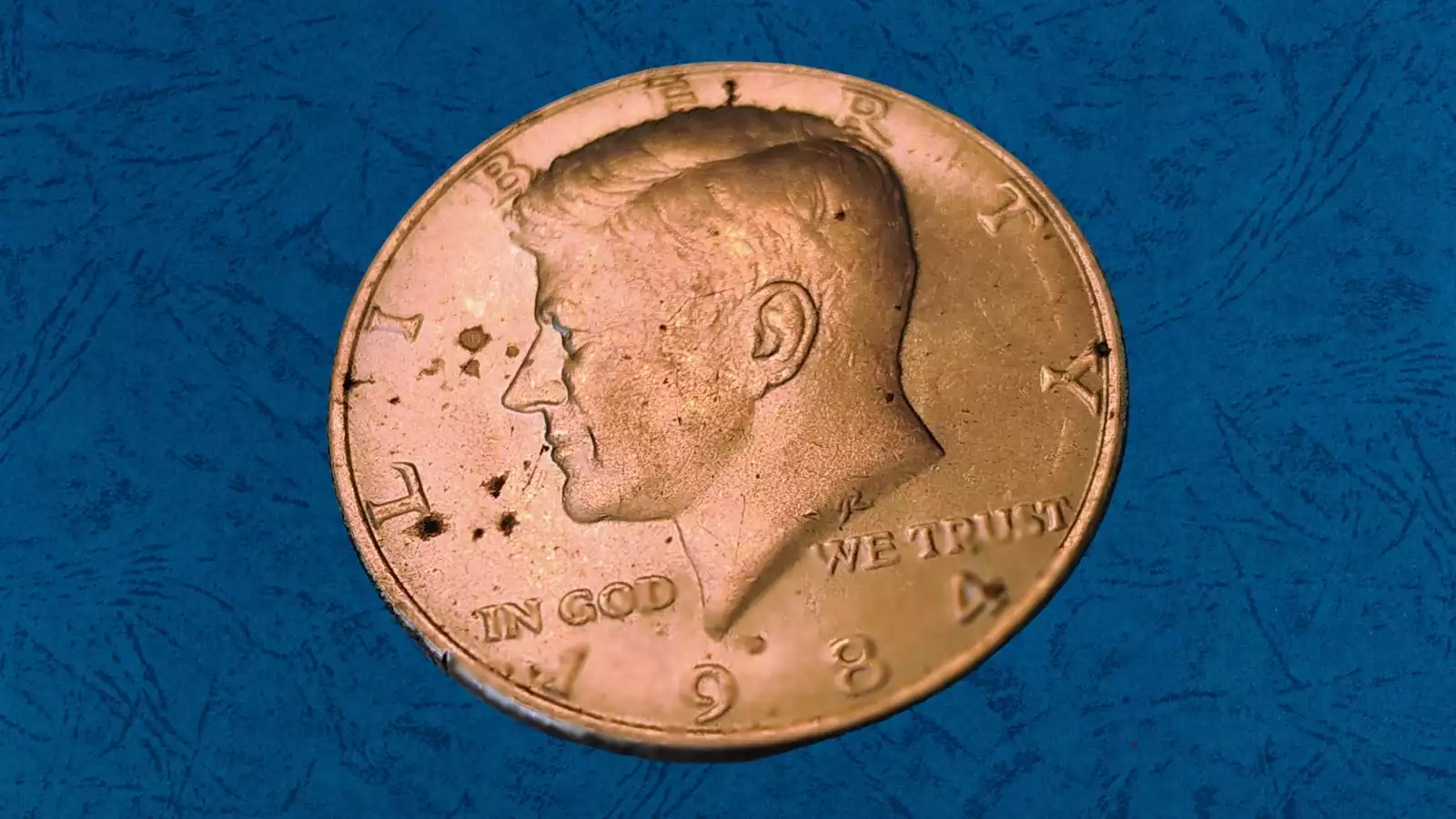 1984-P Kennedy half dollar off-center strike error with crescent blank area and full date visible